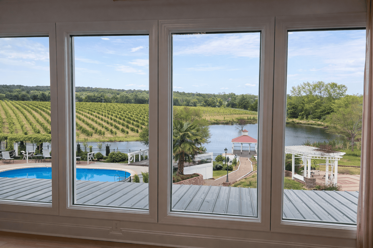 Vineyard and lake view from luxury bed and breakfast near Charlotte NC with panoramic windows overlooking grapevines, pool, and gazebo at Laurel Haven Estate