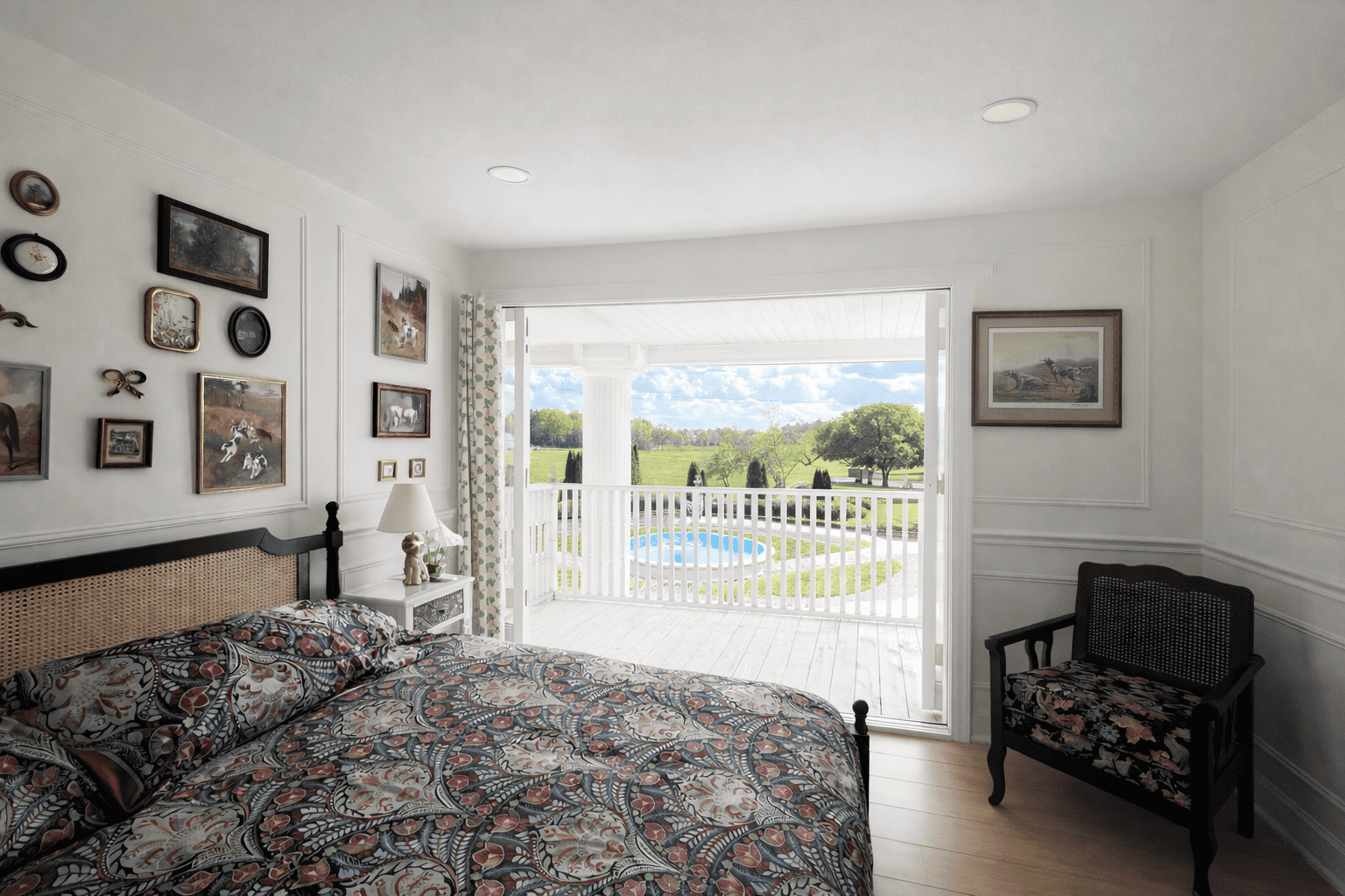 Bright, airy bedroom in Laurel Haven Estate’s Dogwood Suite featuring a king bed with patterned bedding, elegant gallery wall, and fully opened French doors leading to a private balcony overlooking the fountain and scenic countryside.