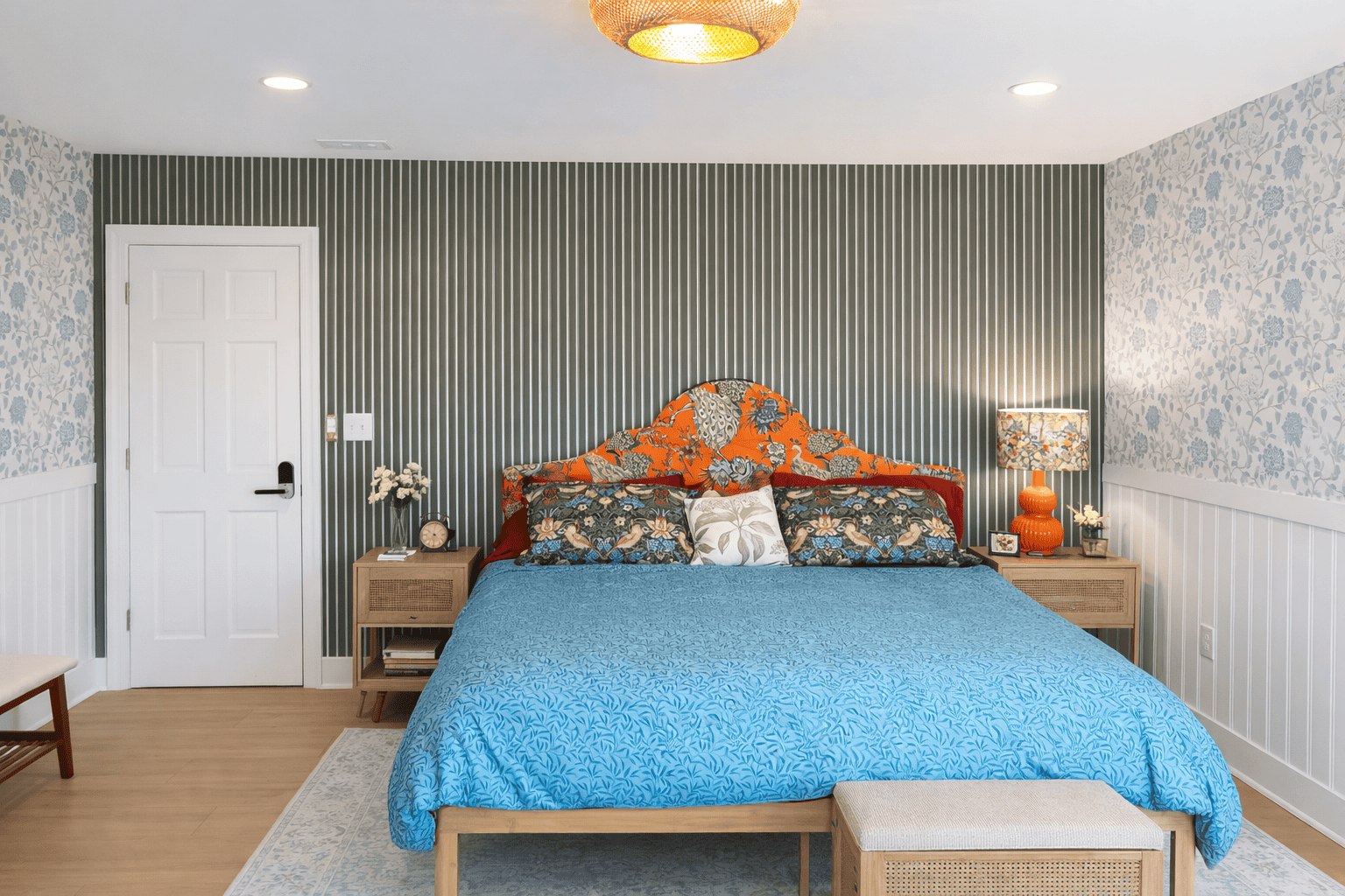 Jessamine Suite king bedroom at Laurel Haven Estate in Lancaster SC featuring patterned wallpaper, colorful upholstered headboard, blue bedding, styled nightstands, and bright elegant design in a luxury bed and breakfast